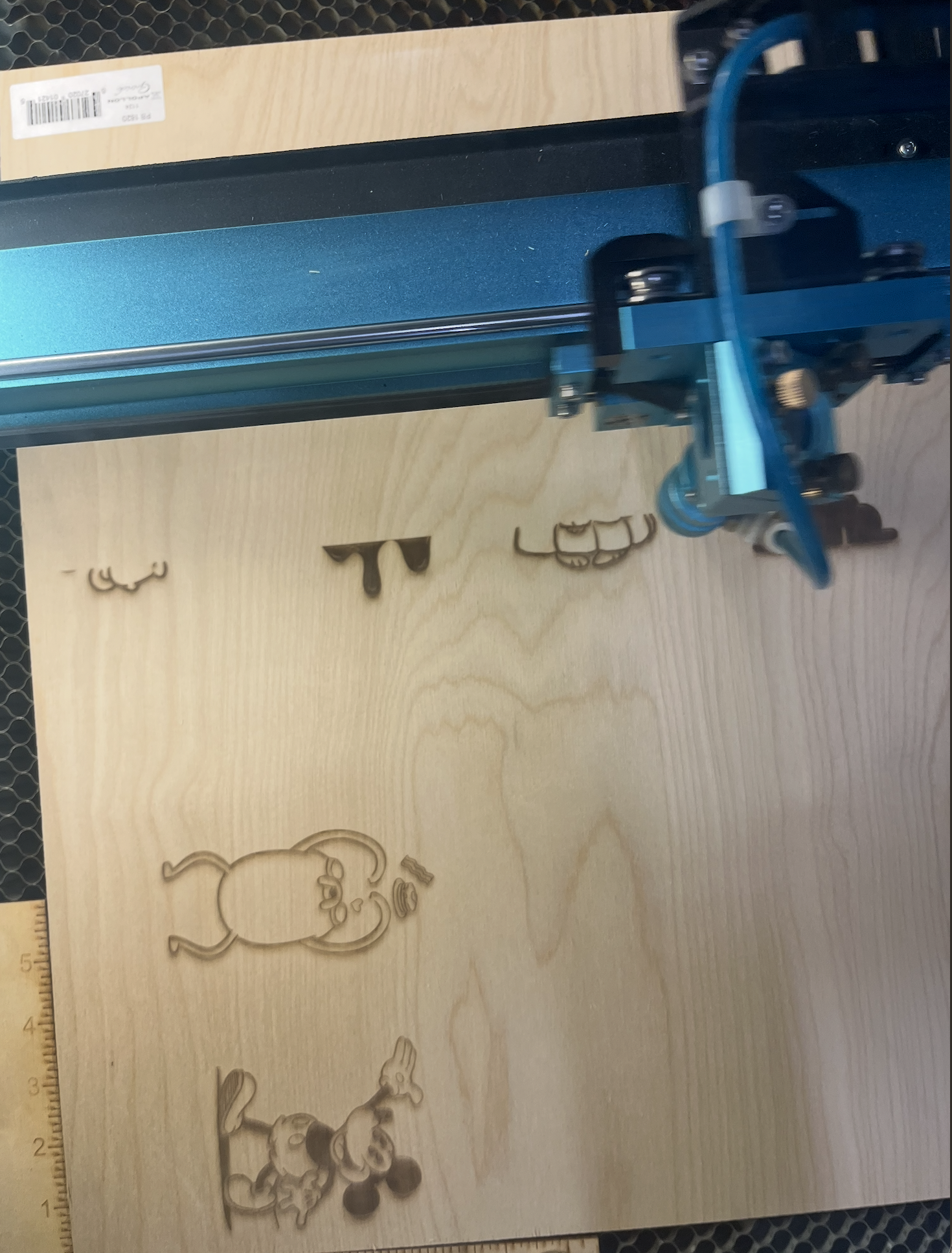 An image taken while working in a group to complete the laser cutting activity as the laser appears on the wood.